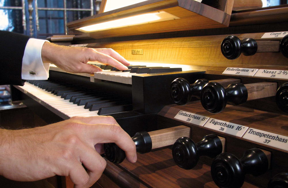 Nahaufnahme von Händen auf einer Kirchenorgel