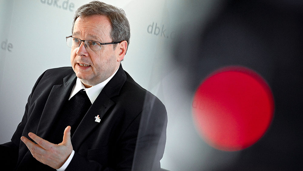 Mann in schwarzer Kleidung, rechts leuchtet eine rote Lampe