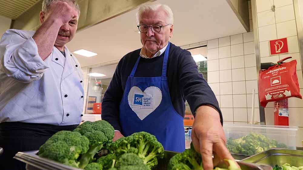 Steinmeier mit Küchenschürze, greift sich Kohlrabi