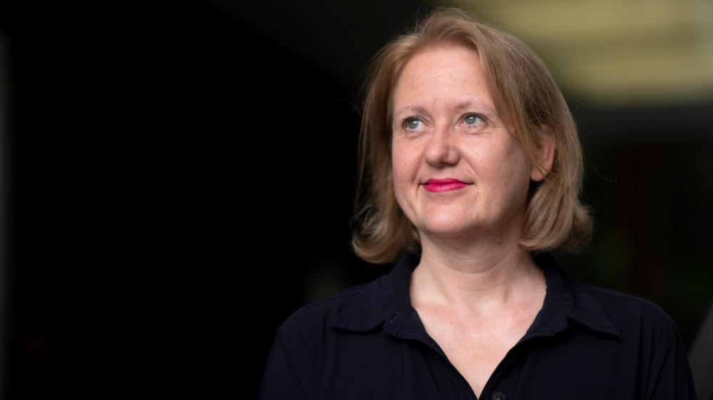 Lisa Paus lächelt vor einem dunklen Hintergrund