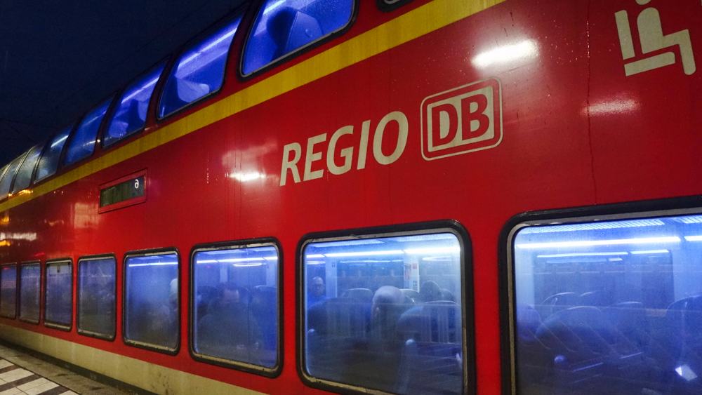 Eine rote Regionalbahn der DB steht nachts an einem Gleis