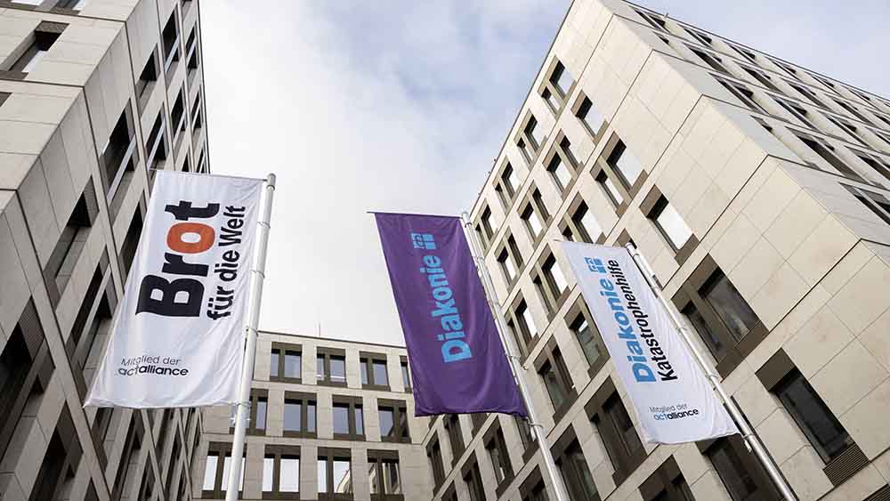 Bürogebäude von außen, Fahnen wehen davor