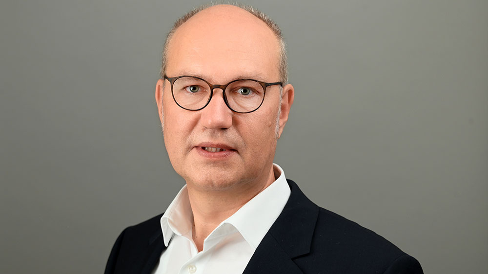 Porträtfoto Mann mit Brille und Glatze