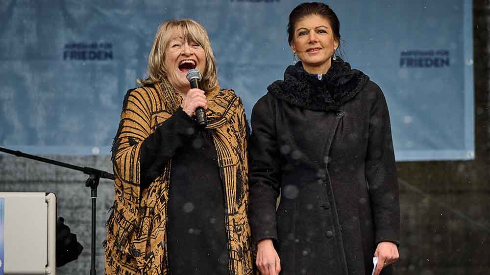 Schwarzer und Wagenknecht mit Mikrofonen auf einer Bühne