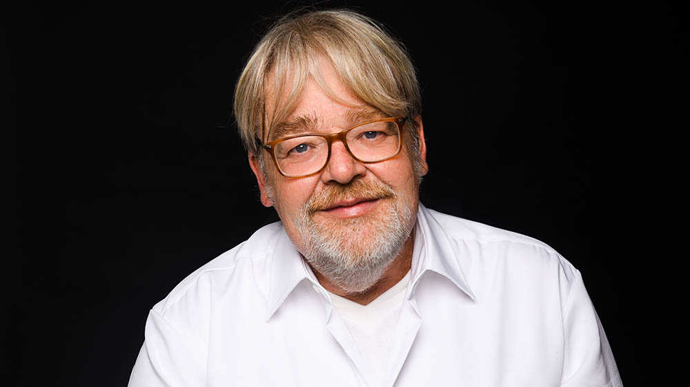 Porträtfoto Mann im weißen Hemd mit Bart und Brille