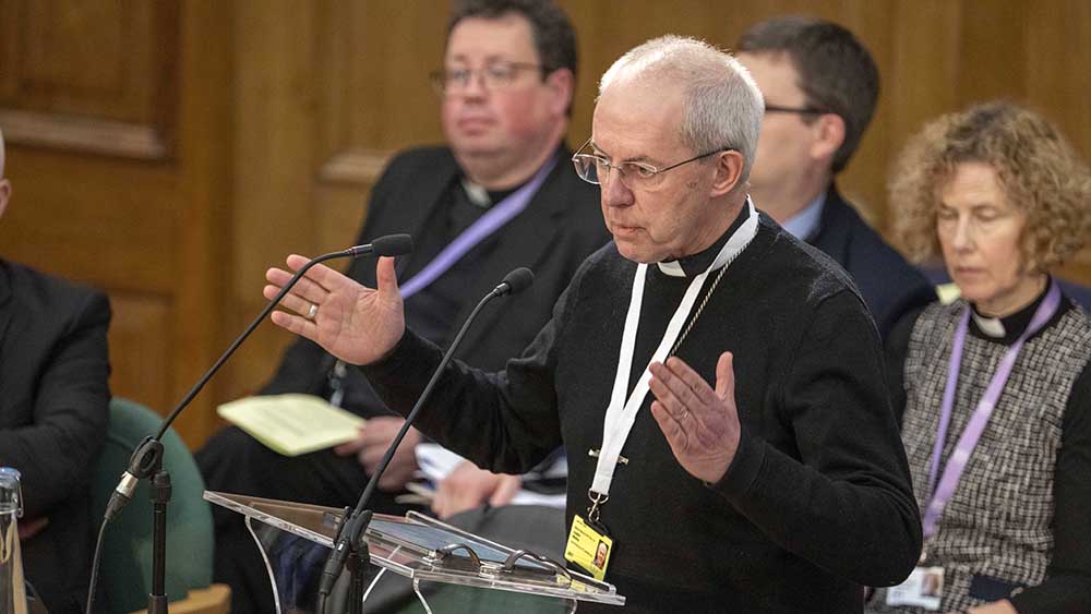 Mann mit Brille und grauen Haaren steht an einem Rednerpult