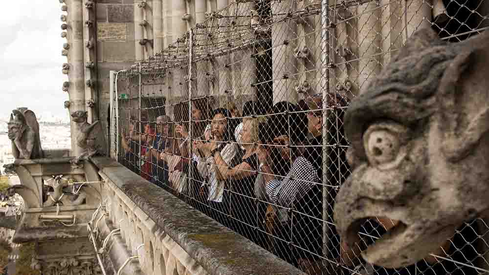 Menschen stehen auf einem abgezäunten Balkon einer Kirche