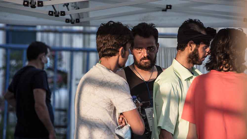 Männer stehen unter einem Zeltdach und reden miteinander