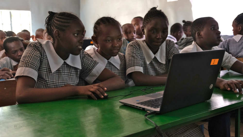 Schülerinnen aus Nairobi arbeiten in der Schule mit einem Laptop