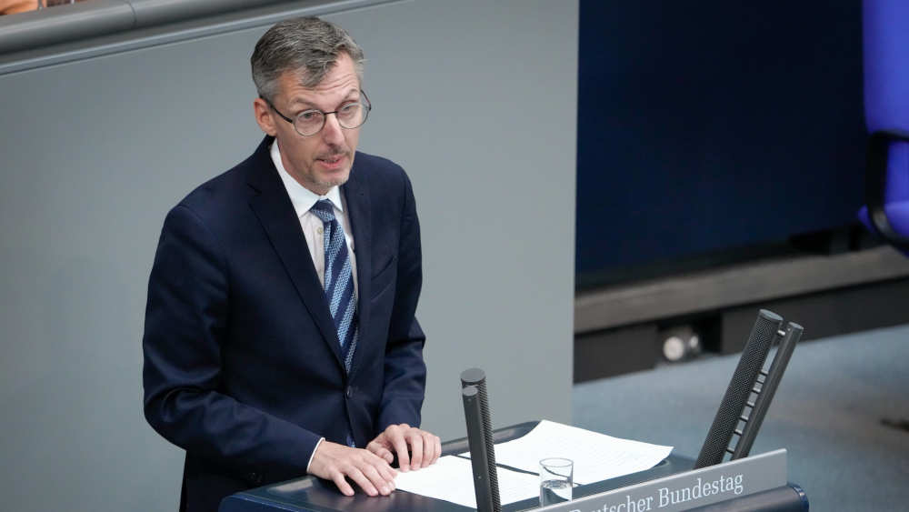 Mann im Anzug steht im Rednerpult des Bundestags