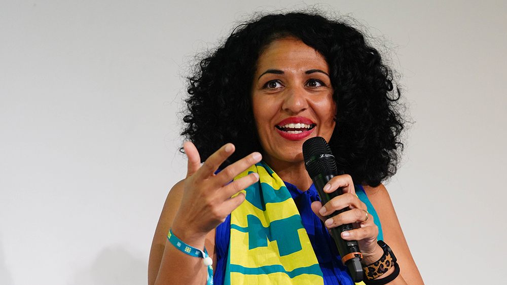 Sarah Vecera spricht mit einem Mikrofon in der Hand.