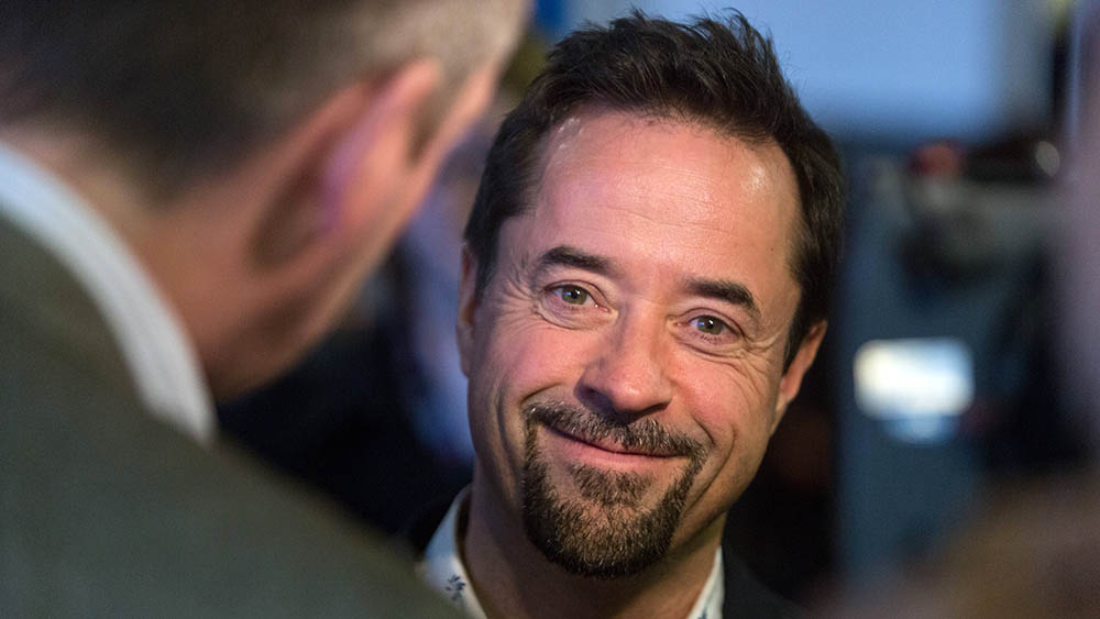 Mann mit dunklen Haaren und Vollbart schaut in die Kamera