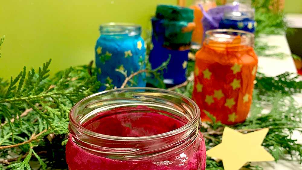Von Kindern mit Transparentpapier beklebte Marmeladengläser dienen im Advent als Dekoration in der Kita.