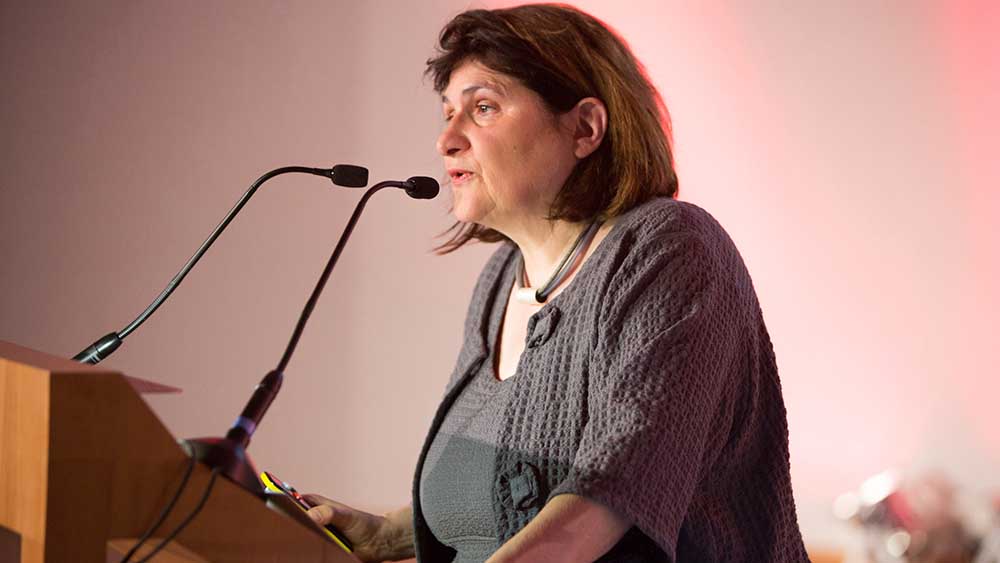 Frau steht an einem Rednerpult