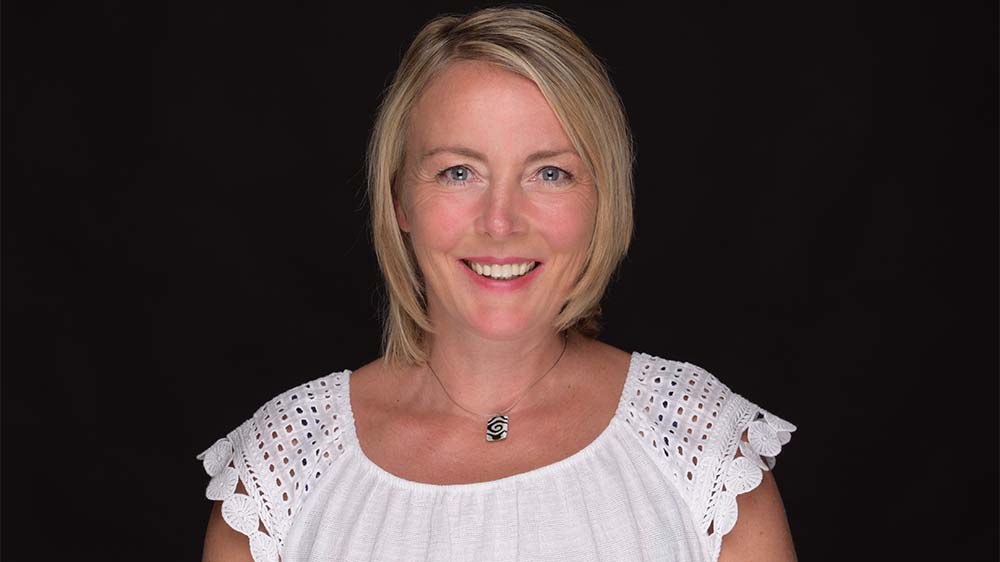 Mittelalte Frau mit kurzen blonden Haaren und weißem Top