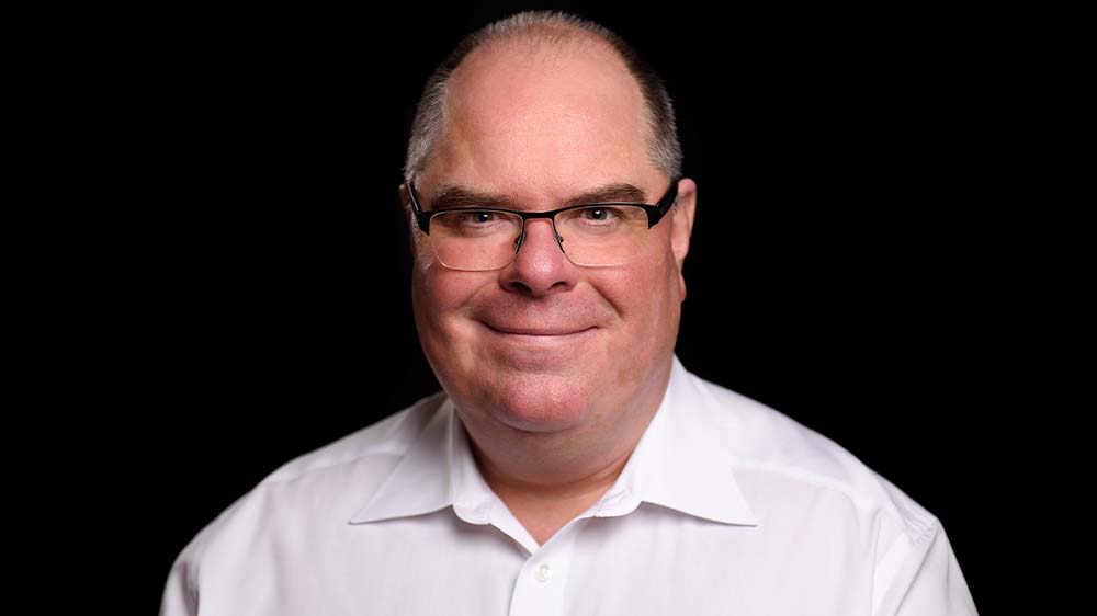 Mann mit Glatze und Brille im weißen Hemd