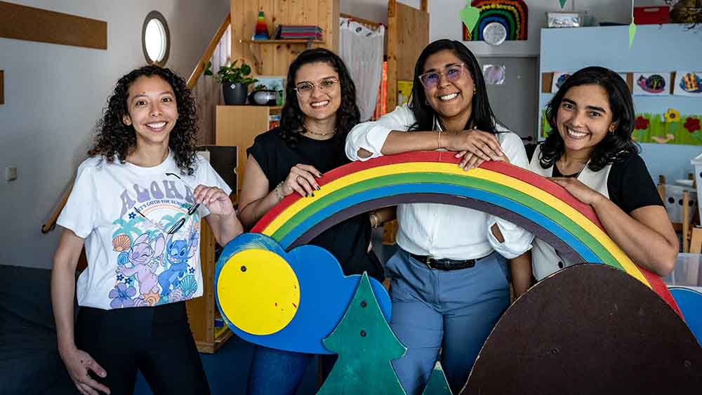 Vier Frau stehen vor einem gebastelten Regenbogen