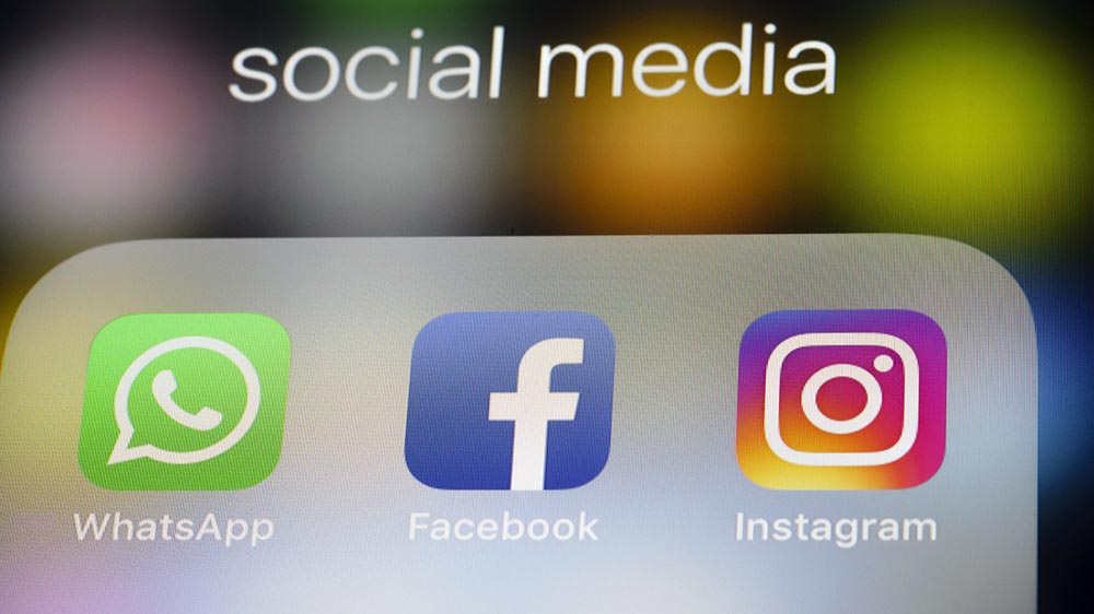 Auf einem Smartphone-Bildschirm sind die Logos von WhatsApp, Facebook und Instagram zu sehen. Über den Logos steht "social media"