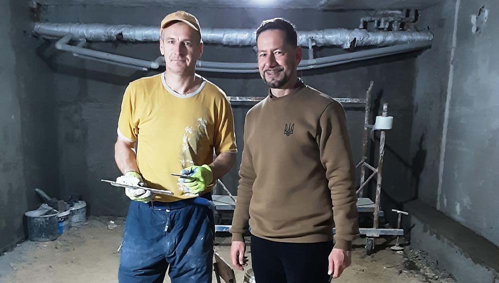 Zwei Männer stehen auf einer Baustelle in einem Bunker