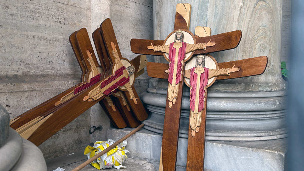Vier Holzkreuze angelehnt an einer Mauer