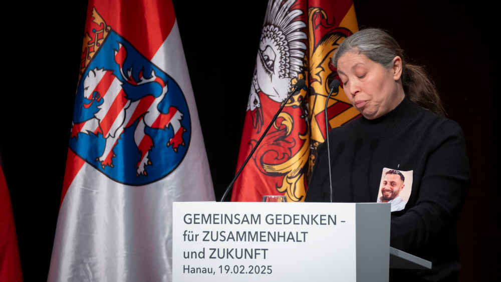 Frau redet am Pult einer Gedenkveranstaltung