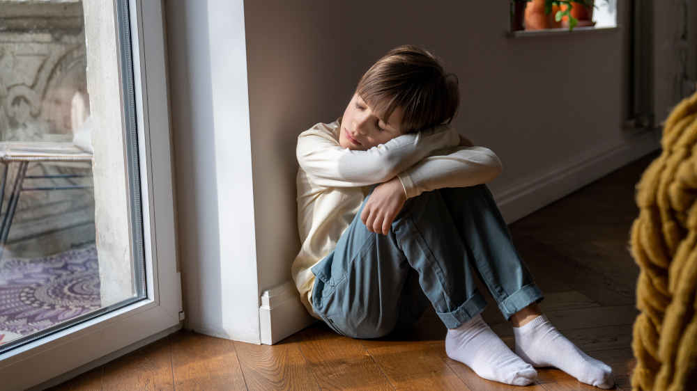 Junge sitzt auf Fußboden und träumt