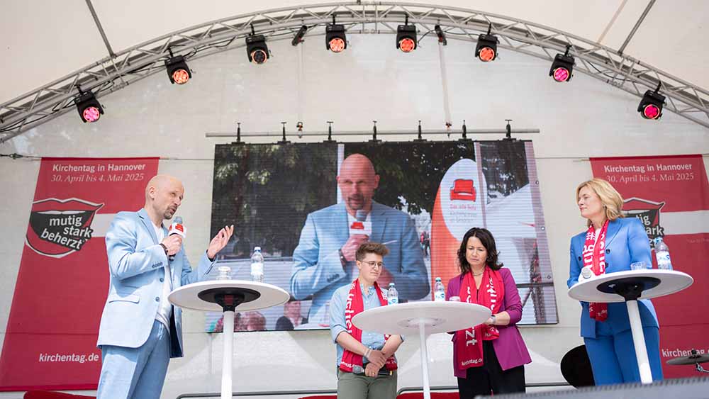 Drei Frauen und ein Mann stehen auf einer Bühne