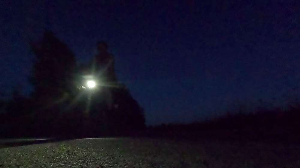 Ein fast schwarzes Bild. Links der Schein einer Fahrradlampe