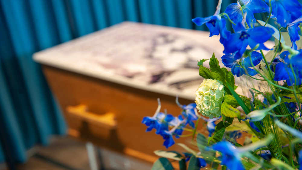 Ein Sarg mit Blumenarrangement in einem Bestattungsinstitut