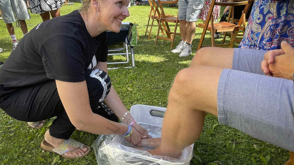 Frau wäscht die Füße einer anderen