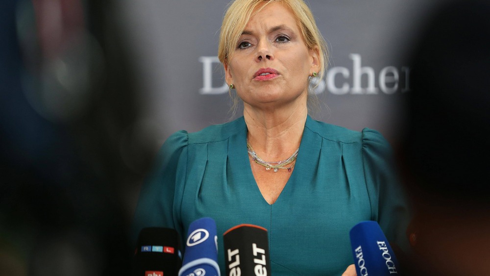 Blonde Frau mit grünem Kleid an Mikros