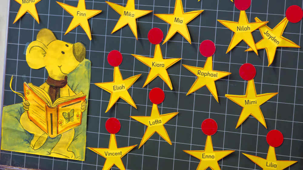 Auf einer Tafel sind Namen von Kindern auf Sterne gemalt