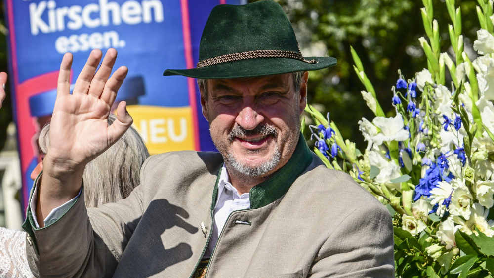 Mann in bayerischen Trachtenanzug winkt