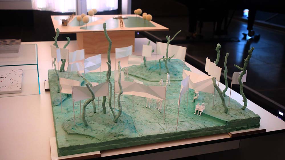 Eine Modell mit weißen Transparenten, Bäumen und Figuren.