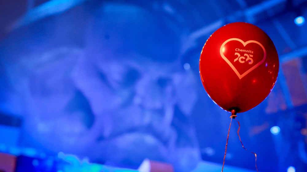 Ein roter Ballon vor einem blauen Bühnenbild