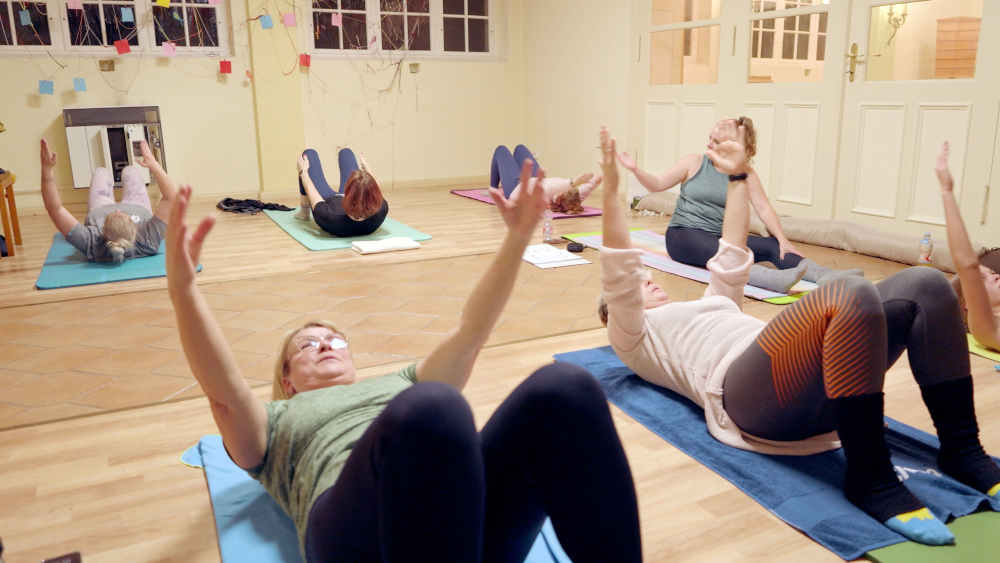 Mehrere Frauen praktizieren Pilates in einem Raum