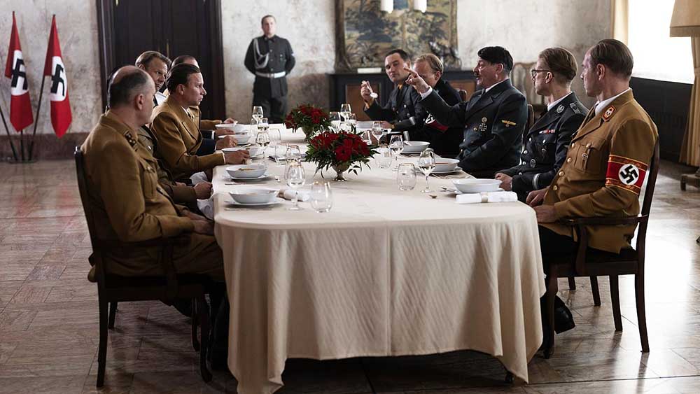 Szene aus dem Dokudrama „Führer und Verführer“. Eine Tafel, an der Hitler und seine Begleiter sitzen.