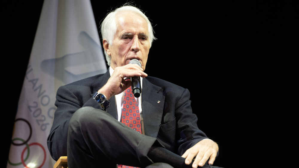 Mann im Anzug spricht mit Mikrofon in der Hand