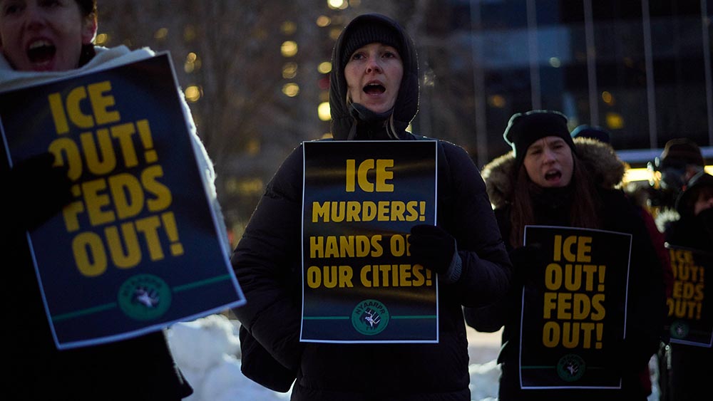 Menschen in dicken Jacken mit Protestplakaten vor der Brust