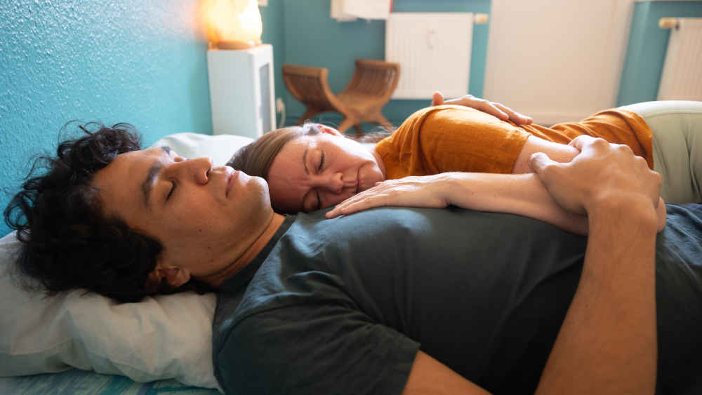 Paar liegt nebeneinander im Bett und schläft