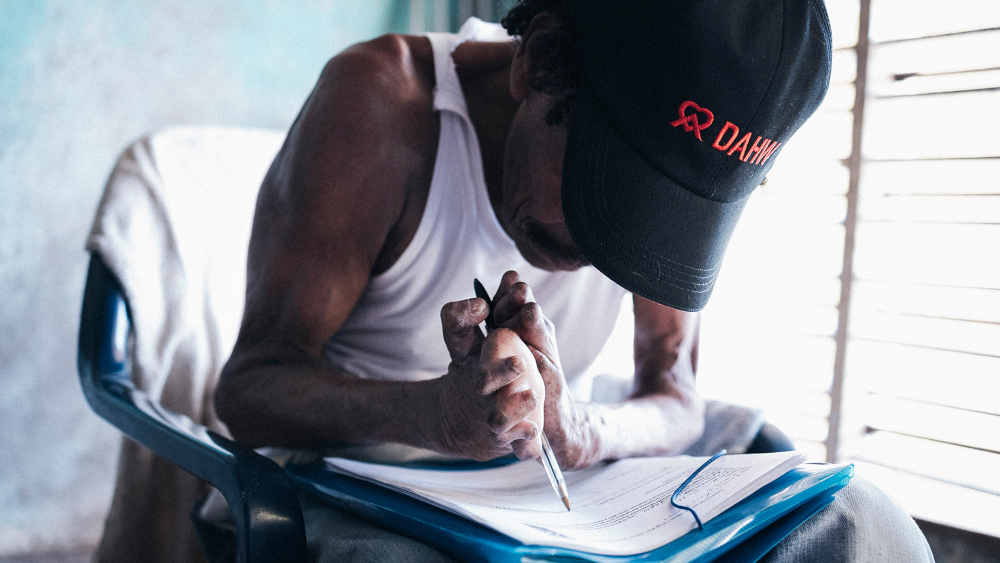 Ein an Lepra erkrankter Mann beim Ausfüllen eines Formulars