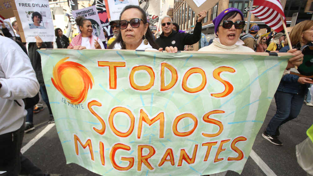 Protestler mit Plakat "Todos Somos Migrantes"