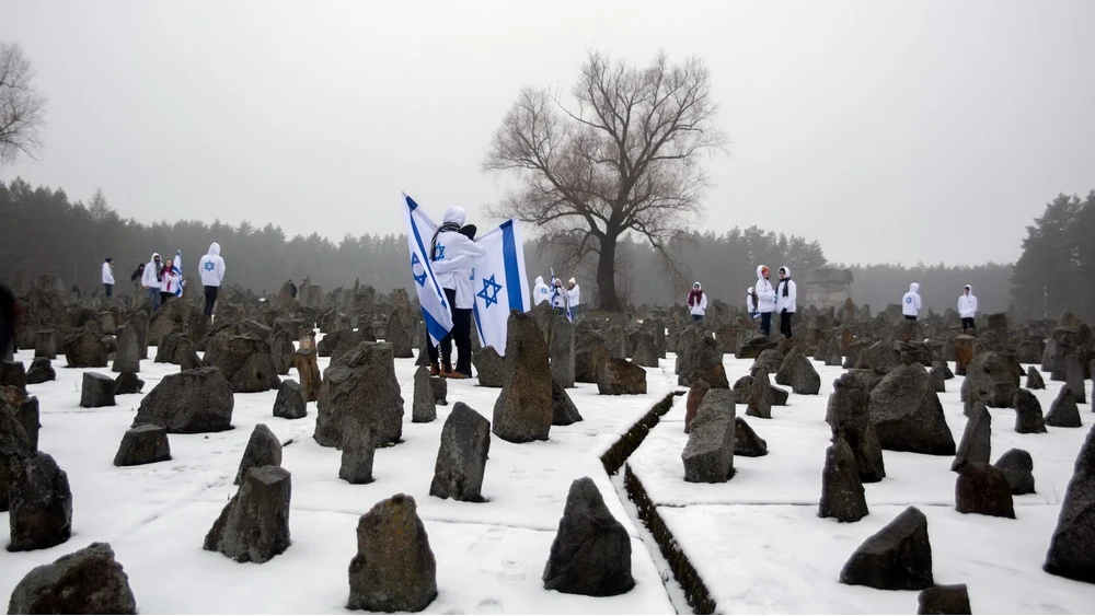 Schüler mit israelischen Flaggen stehen zwischen Steinen