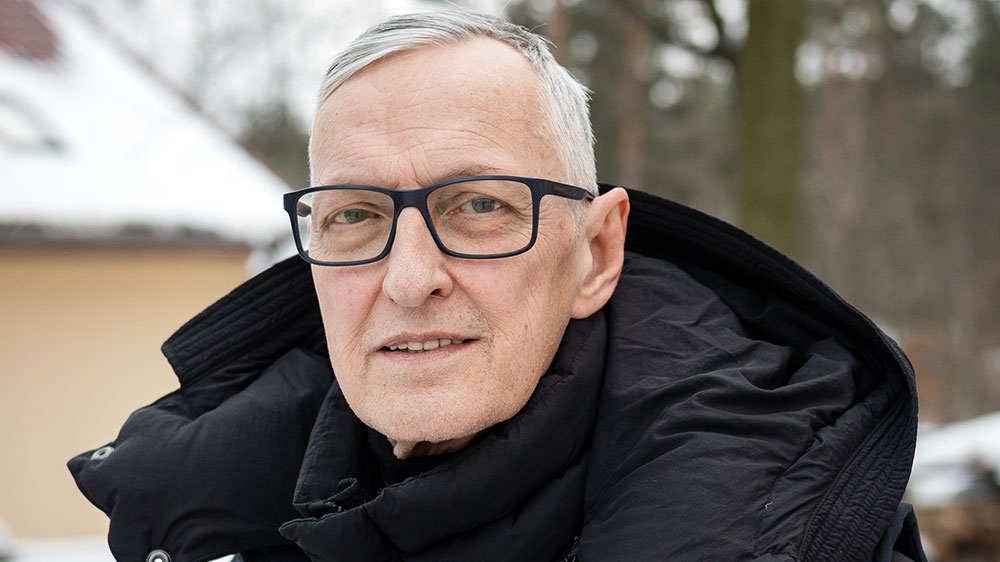 Mann mit Brille und grauen Haaren schaut in Kamera